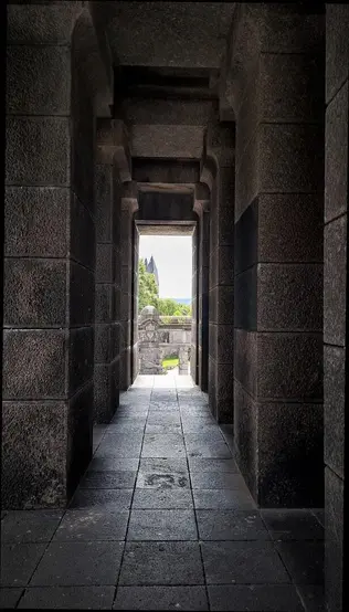 a long hallway with a view of a castle in the distance